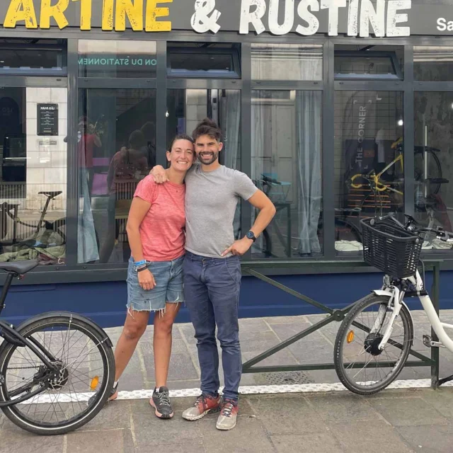 Marine et Damien posent souriants devant leur établissement Tartine & Rustine à Laval. Ils sont , entourés de vélos.