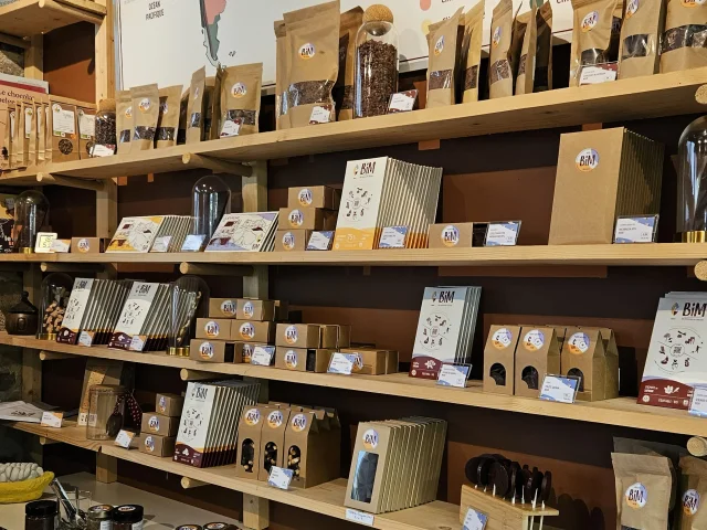 Rayonnage d'une boutique spécialisée dans le cacao et ses produits dérivés, avec une carte des terroirs du cacao en arrière-plan.