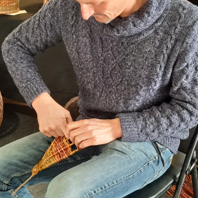 Vannerie d'art F. GASCHT. Gros plan sur des mains créant un panier.