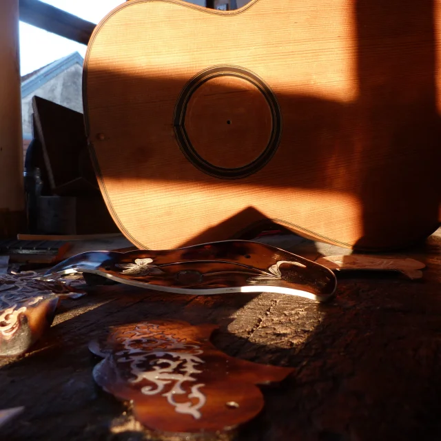 Atelier du musée, lutherie guitare. Détail sur un établi d'une guitare au couché de soleil