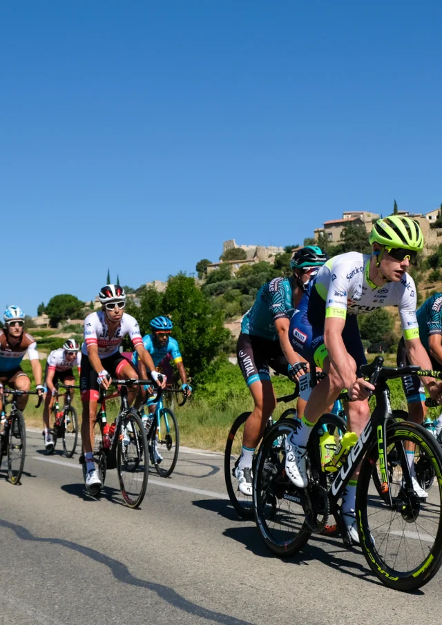 Vorbeifahrt der Radrennfahrer vor dem Dorf Faucon während der 2020er Ausgabe des Mont Ventoux Höhenmeter Challenges.