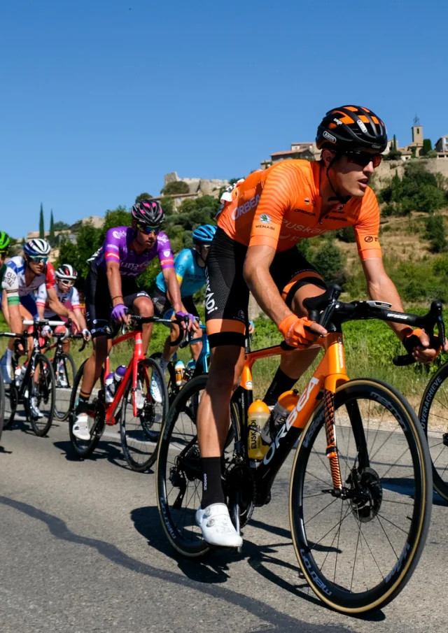 Fietsers passeren voor het dorp Faucon tijdens de 2020 Mont Ventoux denivelé uitdagingen.