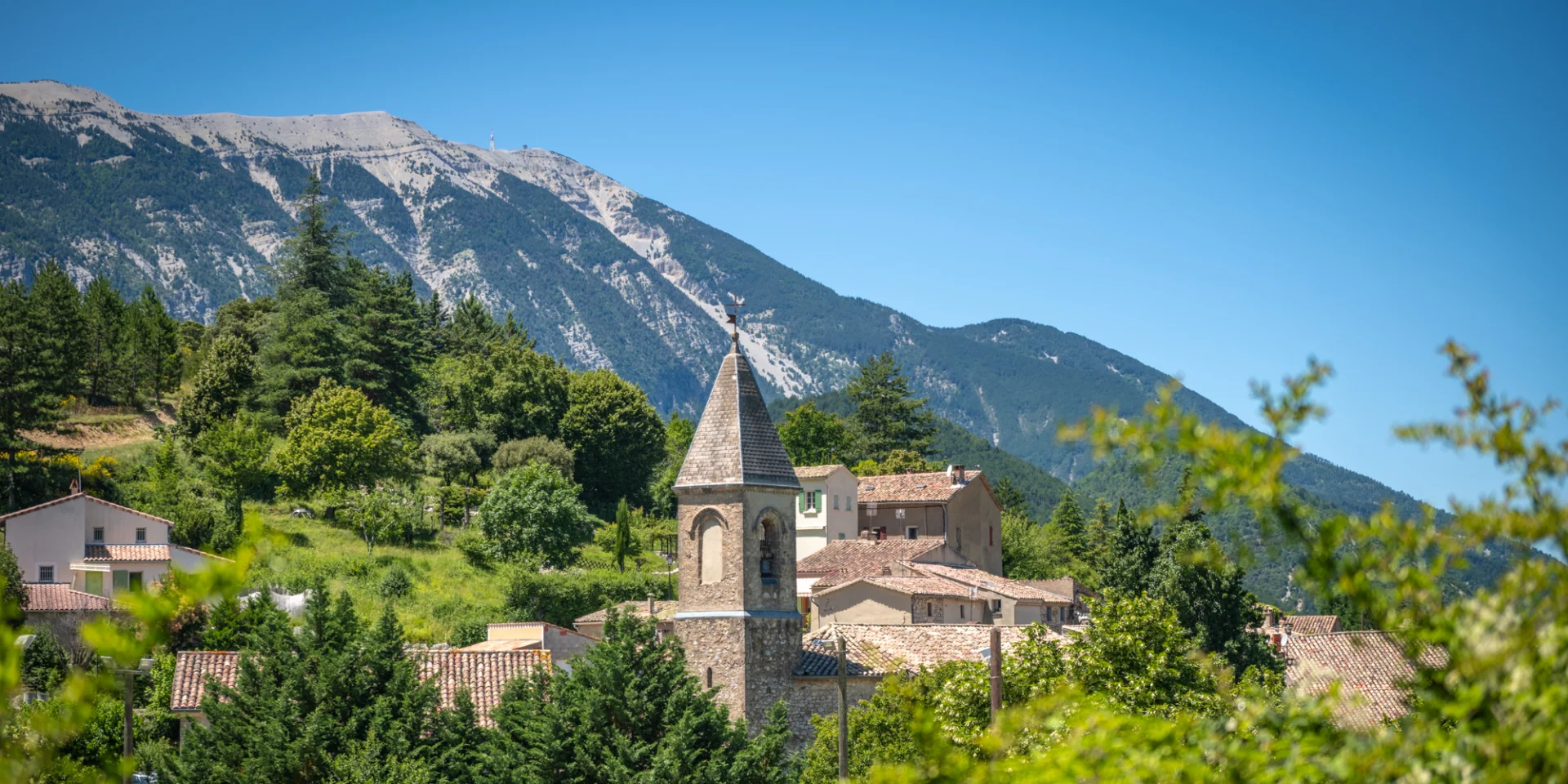 Blick auf den Glockenturm der Dorfkirche von Savoillans mit dem Mont Ventoux im Hintergrund