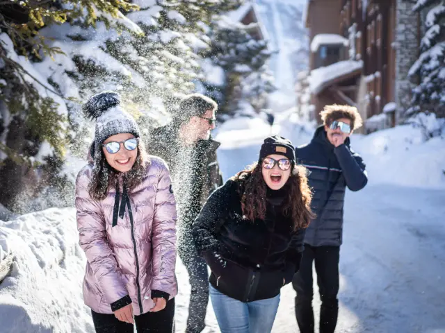 Groupe d'amis qui s'amuse dans le village en hiver