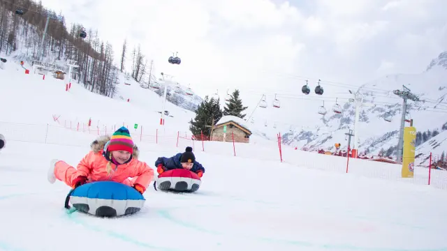 Two children on the snow front human curling in Val d'Isère