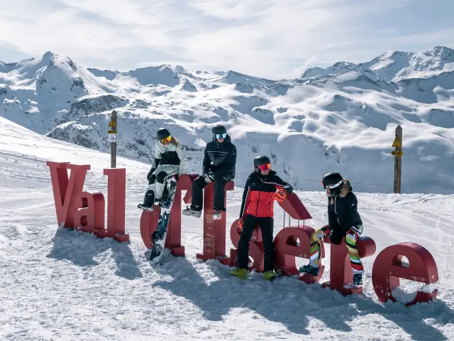 Skieurs et snowbordeurs devant les lettres Val d'Isère