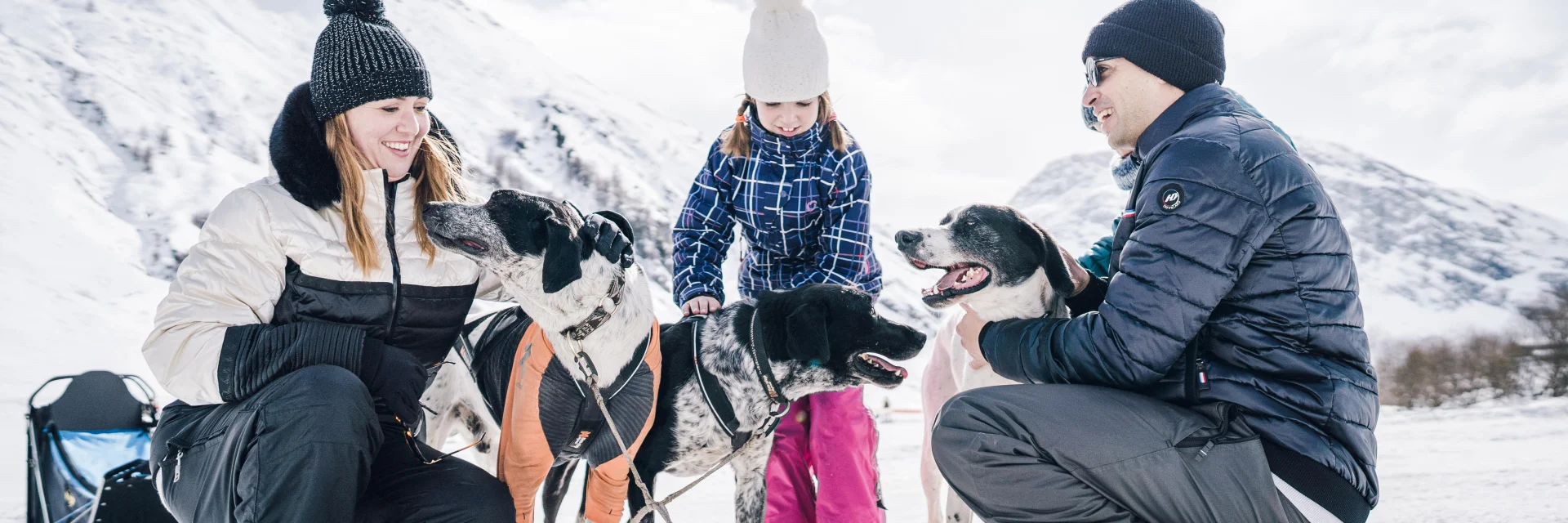 Family with children petting sled dogs in Val d'Isère's Manchet valley