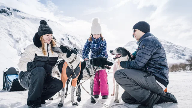 Family with children petting sled dogs in Val d'Isère's Manchet valley