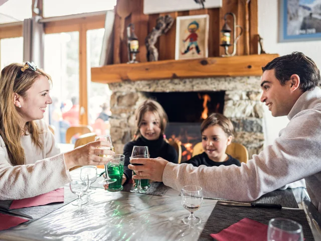 Famille avec enfants à table dans le restaurant Au Bout du Monde dans la vallée du Manchet à Val d'Isère