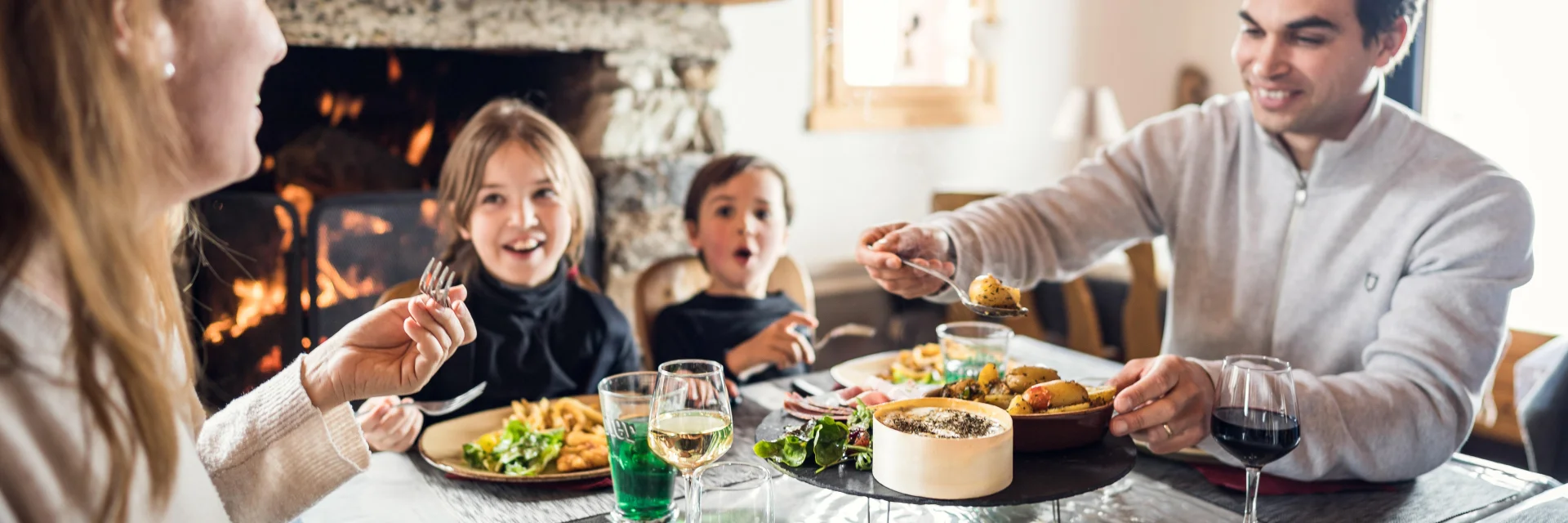 Famille avec enfants à table dans le restaurant Au Bout du Monde dans la vallée du Manchet à Val d'Isère