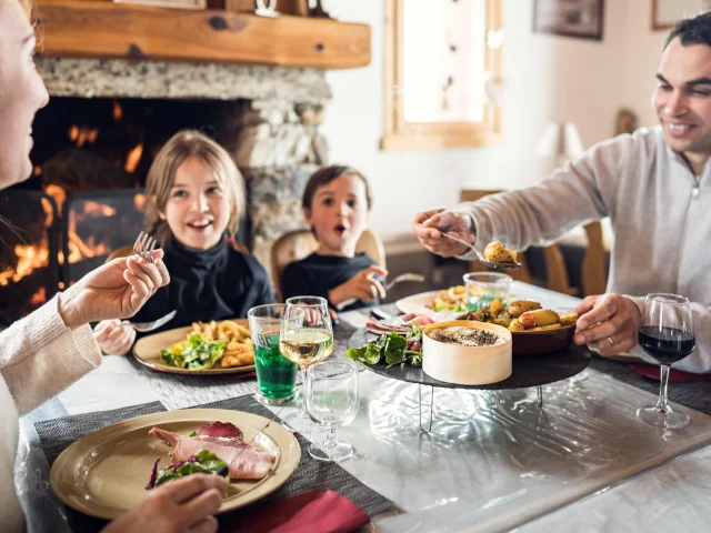 Family with children dining at Au Bout du Monde restaurant in Val d'Isère's Manchet valley