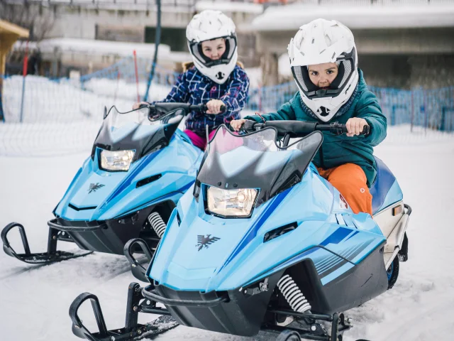 Mini snowmobile with two children playing