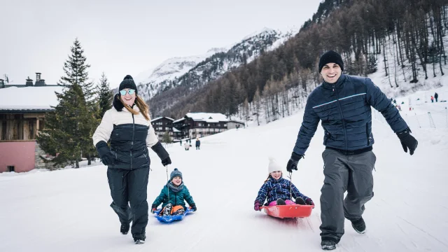 Family with children tobogganing on the Val d'Isère snow front