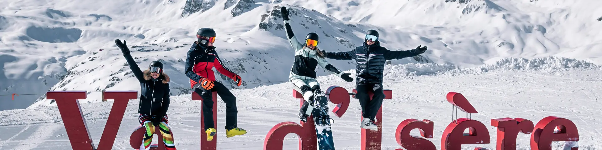 Skiers and snowboarders in front of the Val d'Isère letters