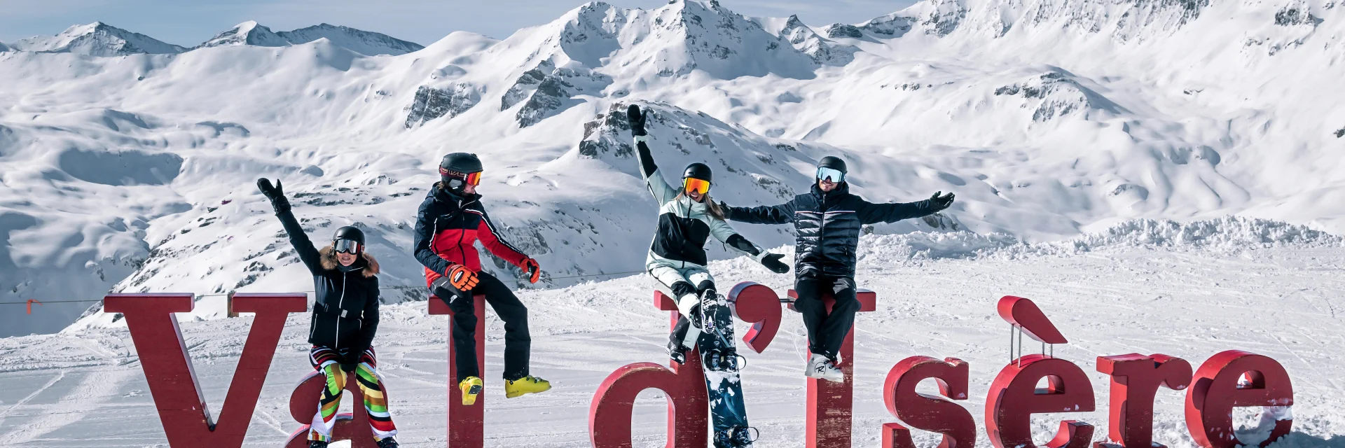 Skieurs et snowbordeurs devant les lettres Val d'Isère