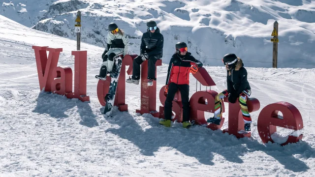 Skiers and snowboarders in front of the Val d'Isère letters