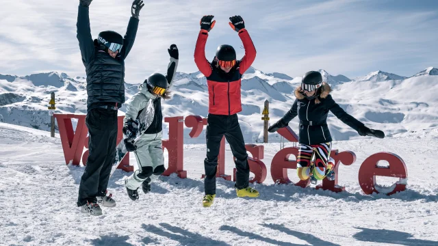 Skiers and snowboarders in front of the Val d'Isère letters