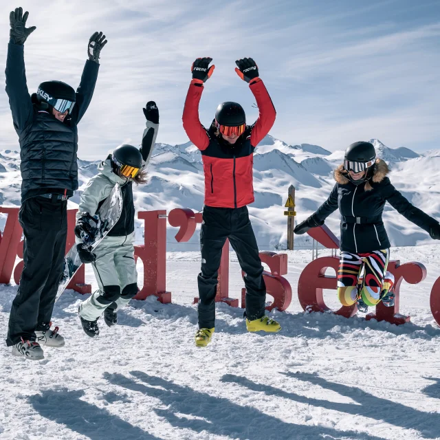 Skiers and snowboarders in front of the Val d'Isère letters