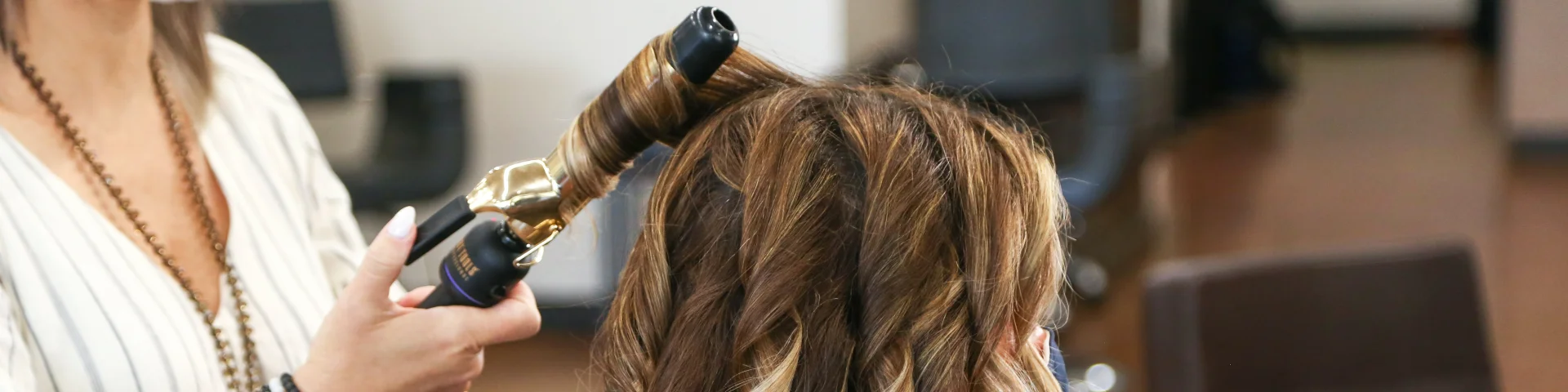 Femme qui se fait coiffer dans un salon de coiffure