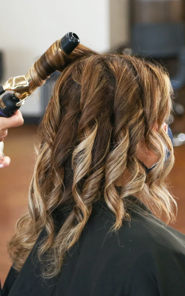 Femme qui se fait coiffer dans un salon de coiffure