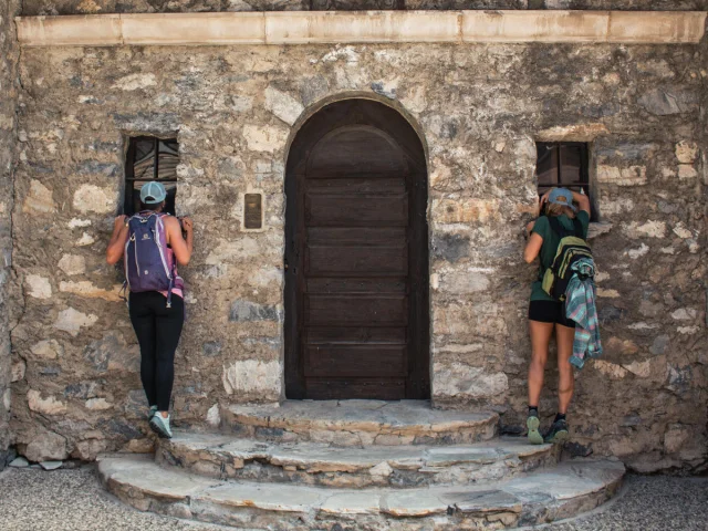 Entrée d'une chapelle à La Daille avec deux marcheurs