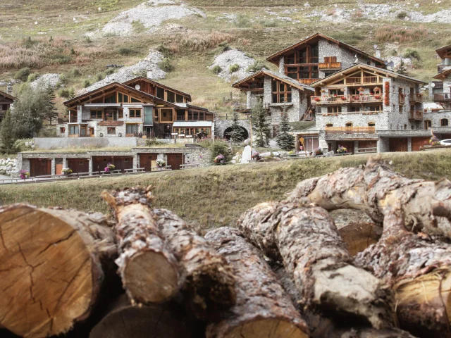 Chalets au Fornet et rondins de bois en premier plan