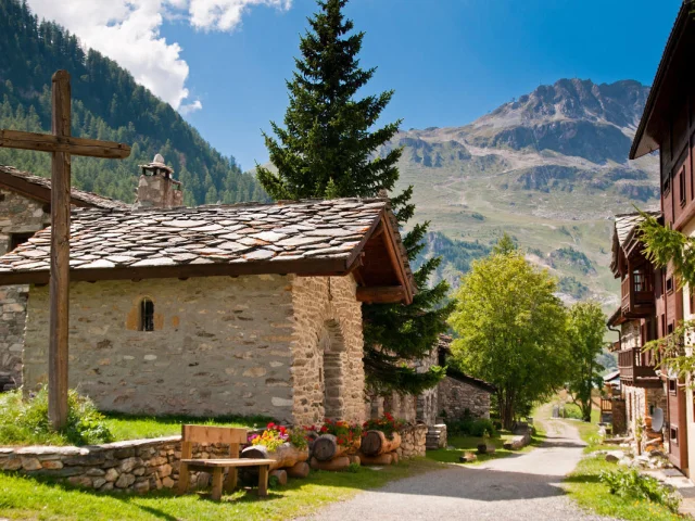 Small chapel in summer with a view of the mountains in the background