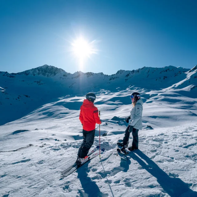 Skiers and snowboarders looking at the mountains in Val d'Isère