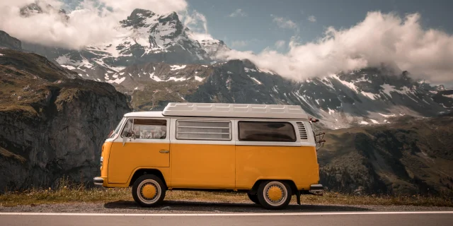 Old van on the road with mountains in the background