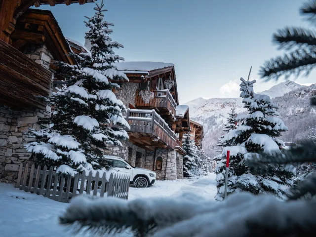 Val d'Isère's Avenue Olympique, chalet and fir under the snow