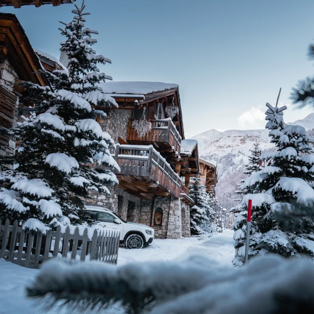 Val d'Isère's Avenue Olympique, chalet and fir under the snow