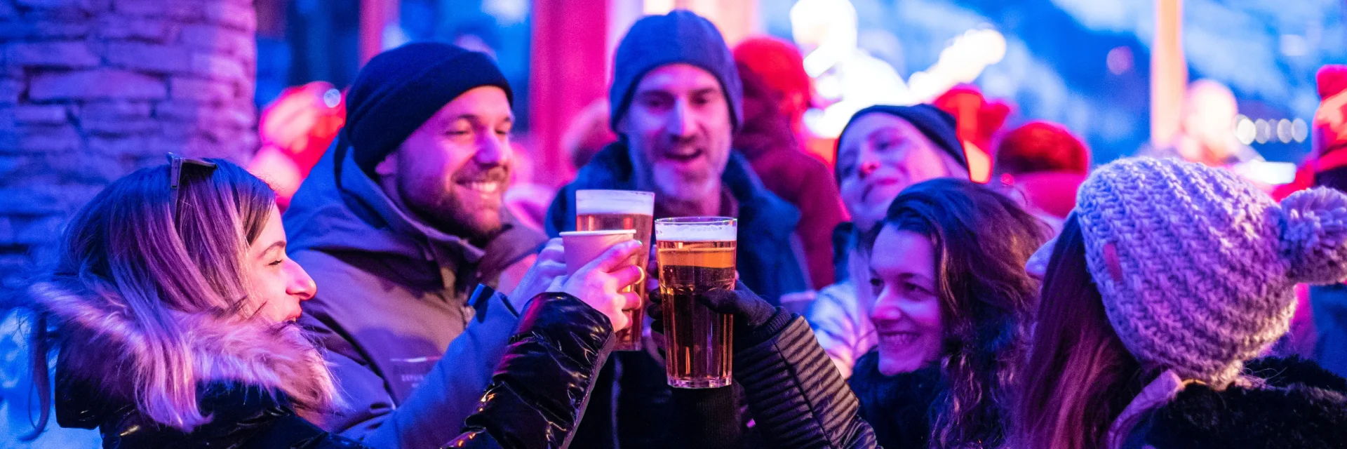 Festive après-ski atmosphere with friends enjoying a drink at the Cocorico bar in winter in Val d'Isère.