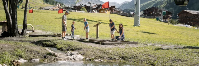 Family mini golf (parents and children) on the Val d'Isère green front in summer