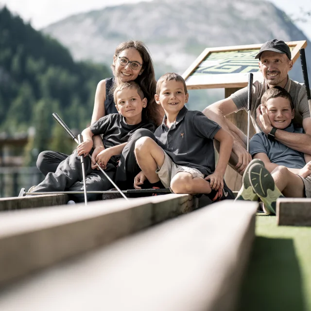 Mini golf en famille (parents et enfant) sur le front de verdure en été à Val d'Isère