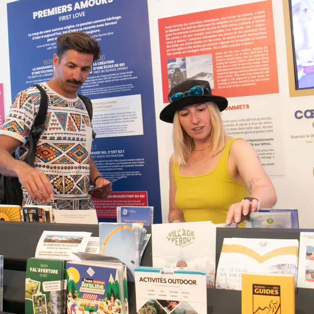 Personnes en train de consulter les brochures à l'Office de Tourisme de Val d'Isère