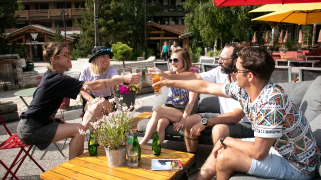 Boire un verre entre amis sur la place de l'Office de Tourisme à Val d'Isère en été