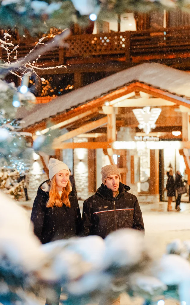 Couple sous la neige devant l'Office de Tourisme