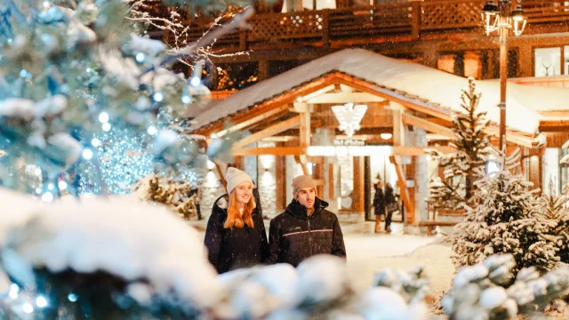 Couple sous la neige devant l'Office de Tourisme