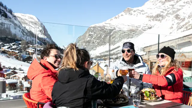 Amis qui trinquent sur la sur terrasse ensoleillée du restaurant L'Étincelle