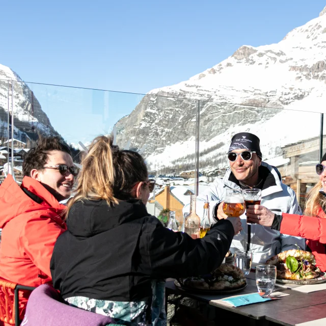 Amis qui trinquent sur la sur terrasse ensoleillée du restaurant L'Étincelle