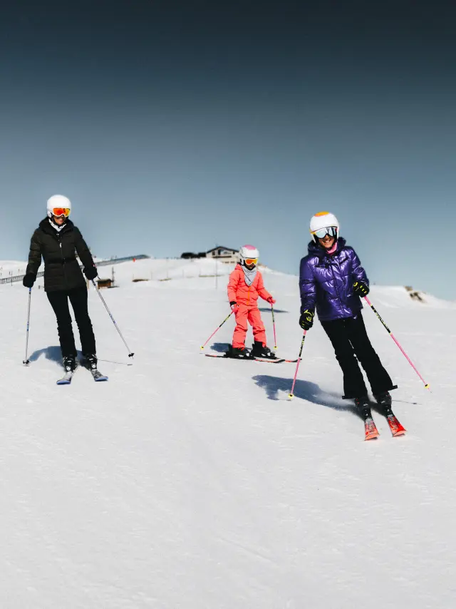 Famille avec adultes et enfants en ski sur les pistes
