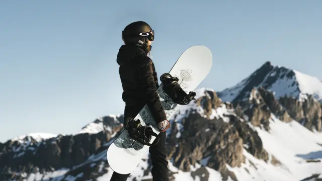 Femme avec son snowboard devant le paysage