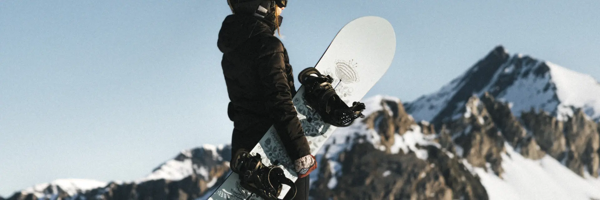 Femme avec son snowboard devant le paysage
