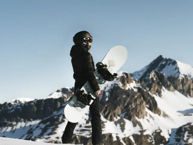Femme avec son snowboard devant le paysage