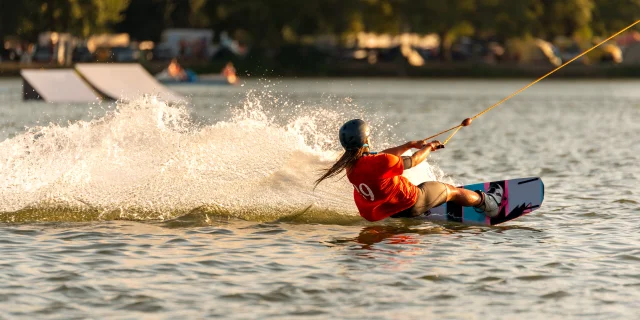 Mujer joven y activa en el wakeboard en el parque de cable Merkur, Nove Mlyny, Moravia del Sur, República Checa.