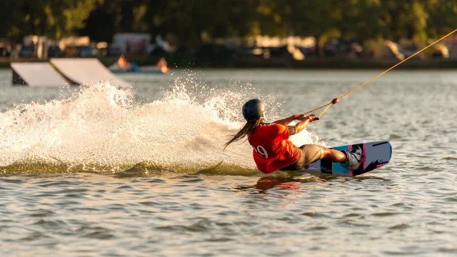 Mujer joven y activa en el wakeboard en el parque de cable Merkur, Nove Mlyny, Moravia del Sur, República Checa.