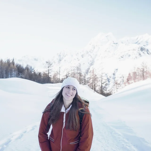 Smiling woman enjoying a snowy mountain landscape