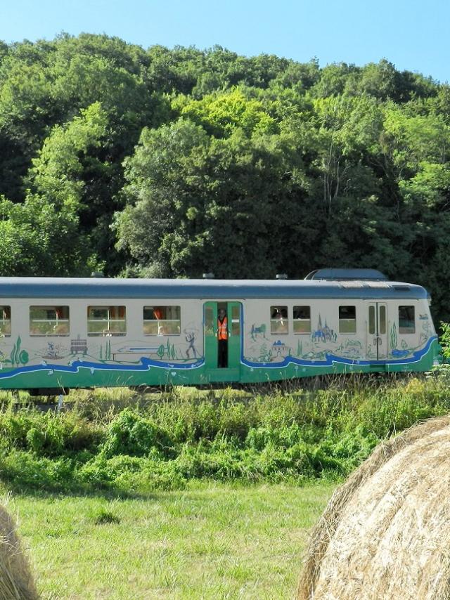 Train touristique avec en premier plan des bottes de paille à la campagne à Thoré-la-Rochette