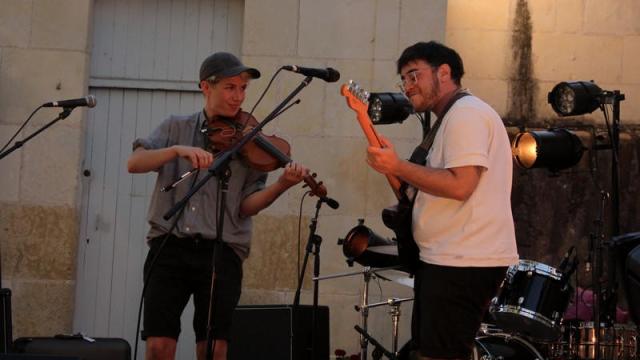 Deux chanteurs avec guitare et violon dans une cour