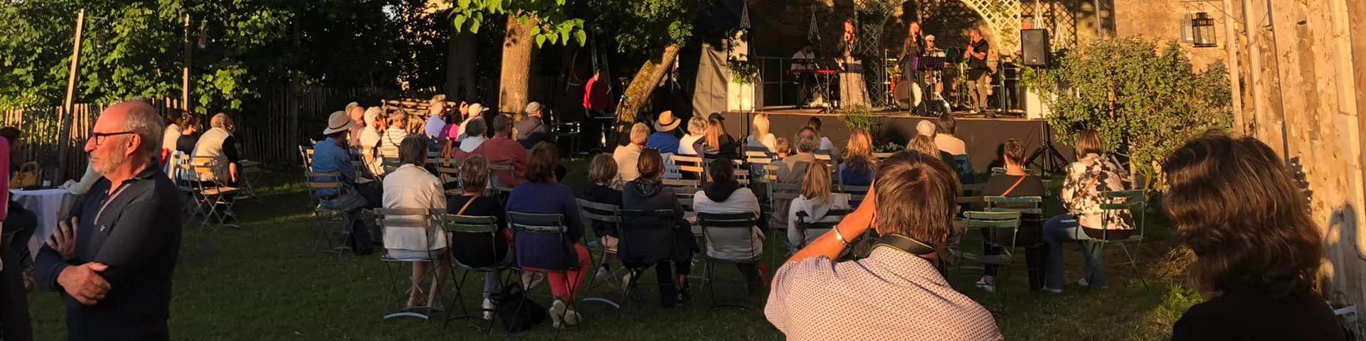 Public debout et assis devant une scène lors d'un concert
